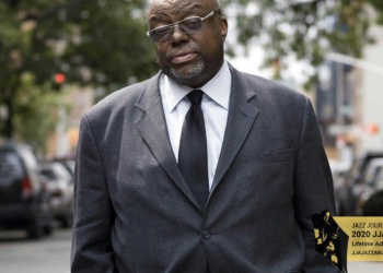 Stanley Crouch standing in the street