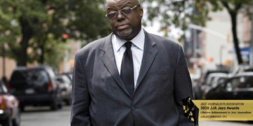 Stanley Crouch standing in the street