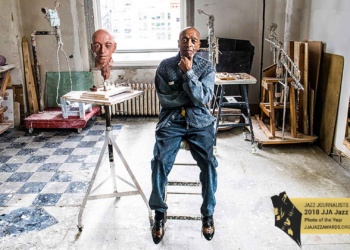 Roy Haynes sitting next to sculpture of himself